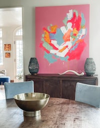 a dining room with a large painting on the wall